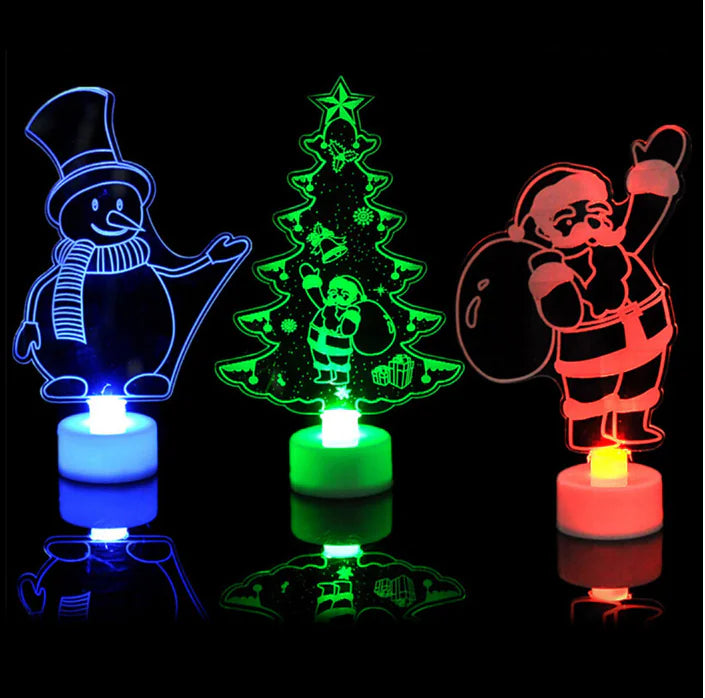 Three colorful LED night lights shaped like a snowman, Christmas tree, and Santa Claus on a black background.
