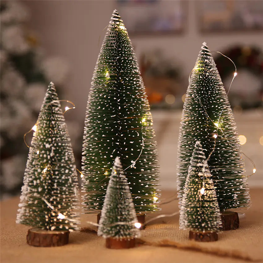 Set of miniature Christmas trees with lights on a neutral background