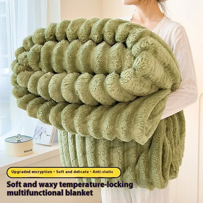 Person holding a green multicolored blanket with text describing its features.