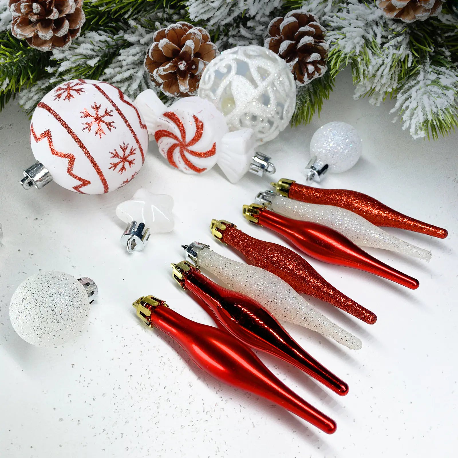 Collection of Christmas ornaments including red and white decorations on a snowy background.