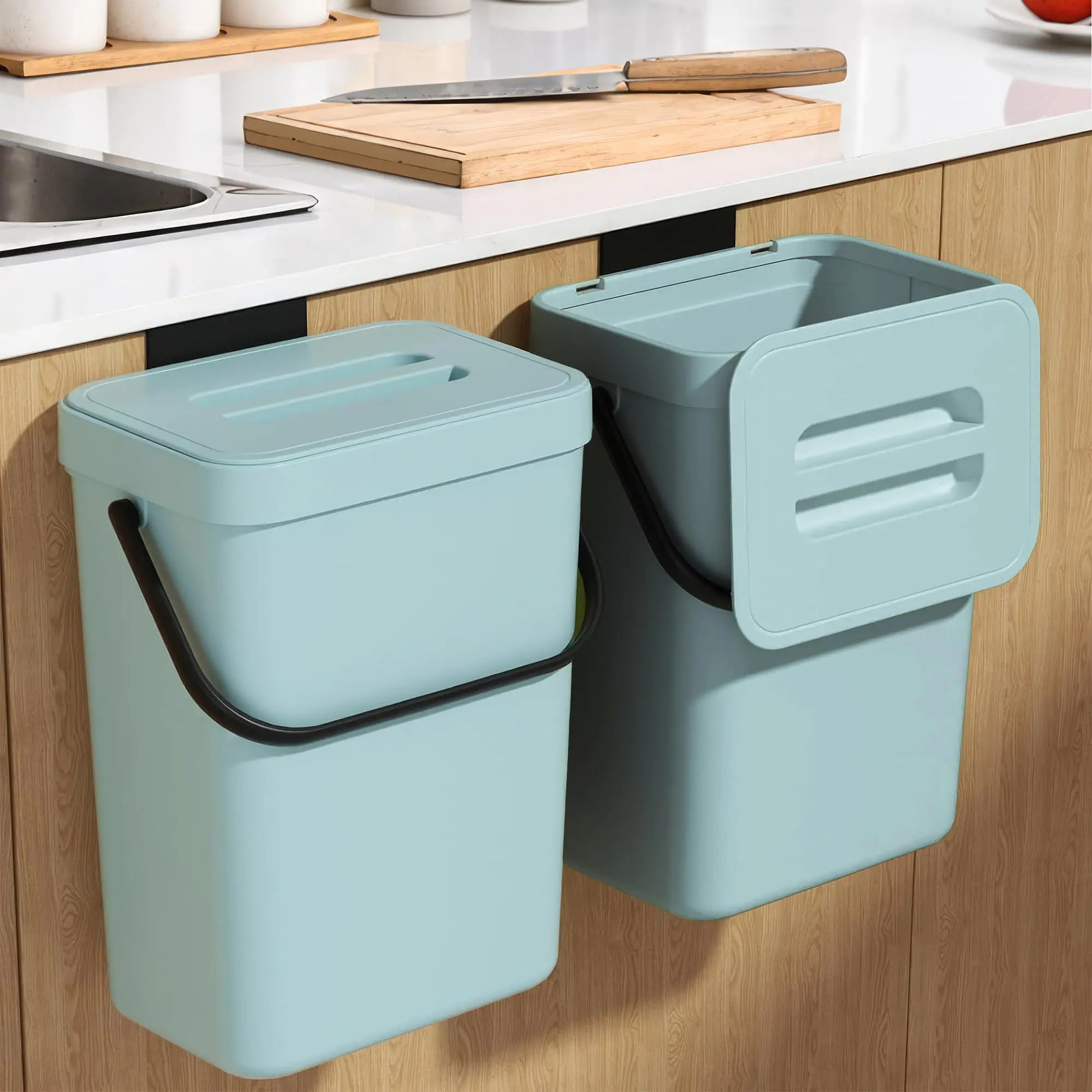 Two light blue wall-mounted trash bins in a kitchen setting.