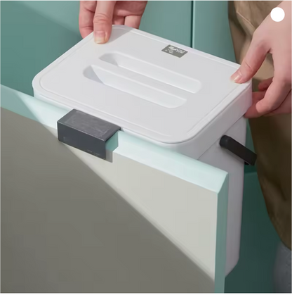 White trash bin with a lid being held by a person against a light green background