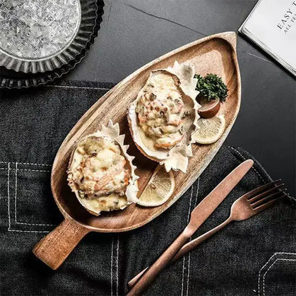 Wooden dish with oysters on a dark surface