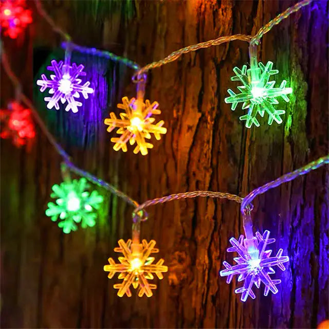 String of colorful snowflake lights against a wooden background