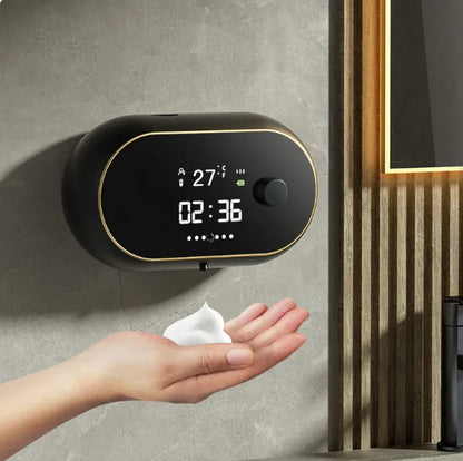 Hand using a digital wall-mounted device to dispense a wipe, with a clock and temperature display.