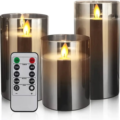 Set of three flameless candles with a remote control on a white background